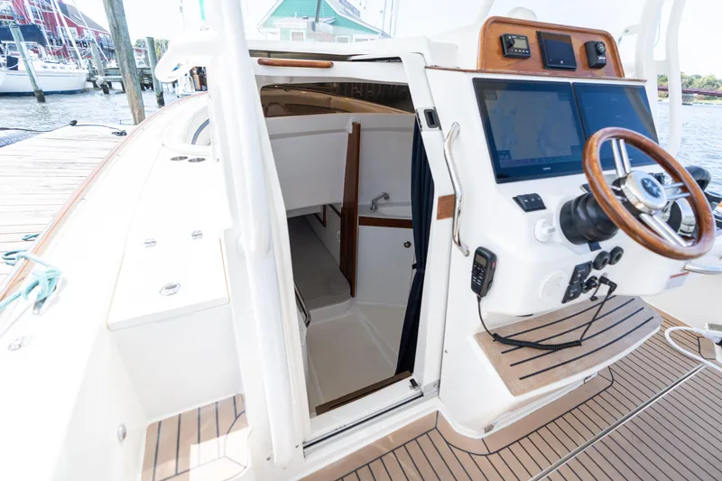 Hunt 32cc-035 Yacht Photos Pics 2019 Hunt Yachts 32CC boat interior with helm, navigation screens, and cabin entrance.