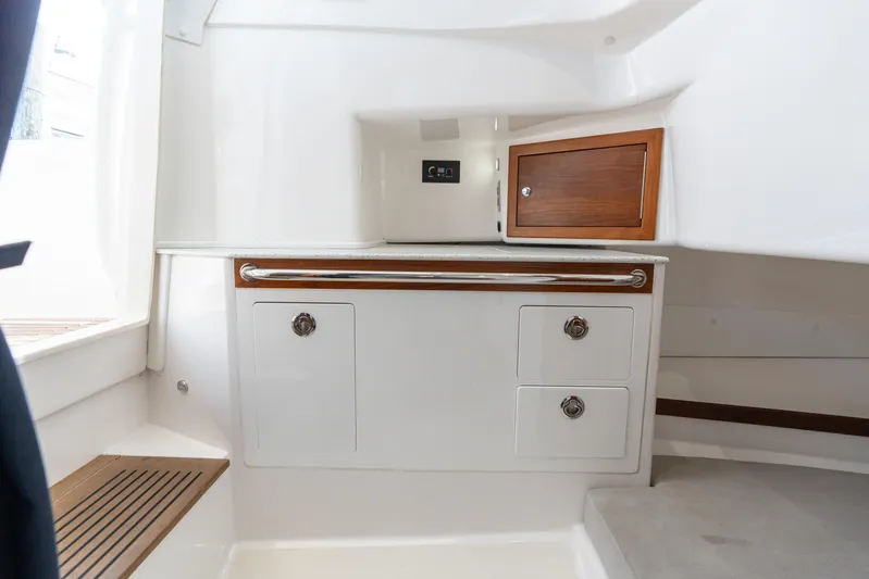 Hunt 32cc-035 Yacht Photos Pics 2019 Hunt Yachts 32 Center Console interior with storage cabinets and wooden accents.