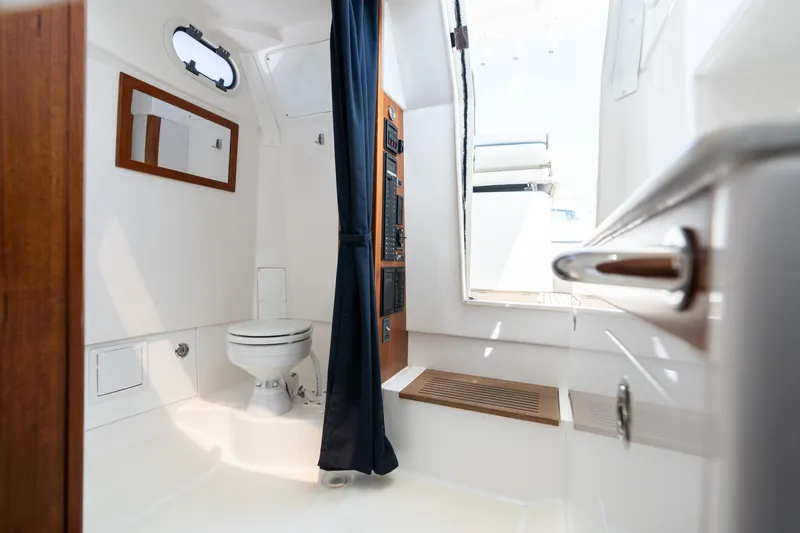 Hunt 32cc-035 Yacht Photos Pics 2019 Hunt Yachts 32CC interior with toilet, mirror, and wooden accents.