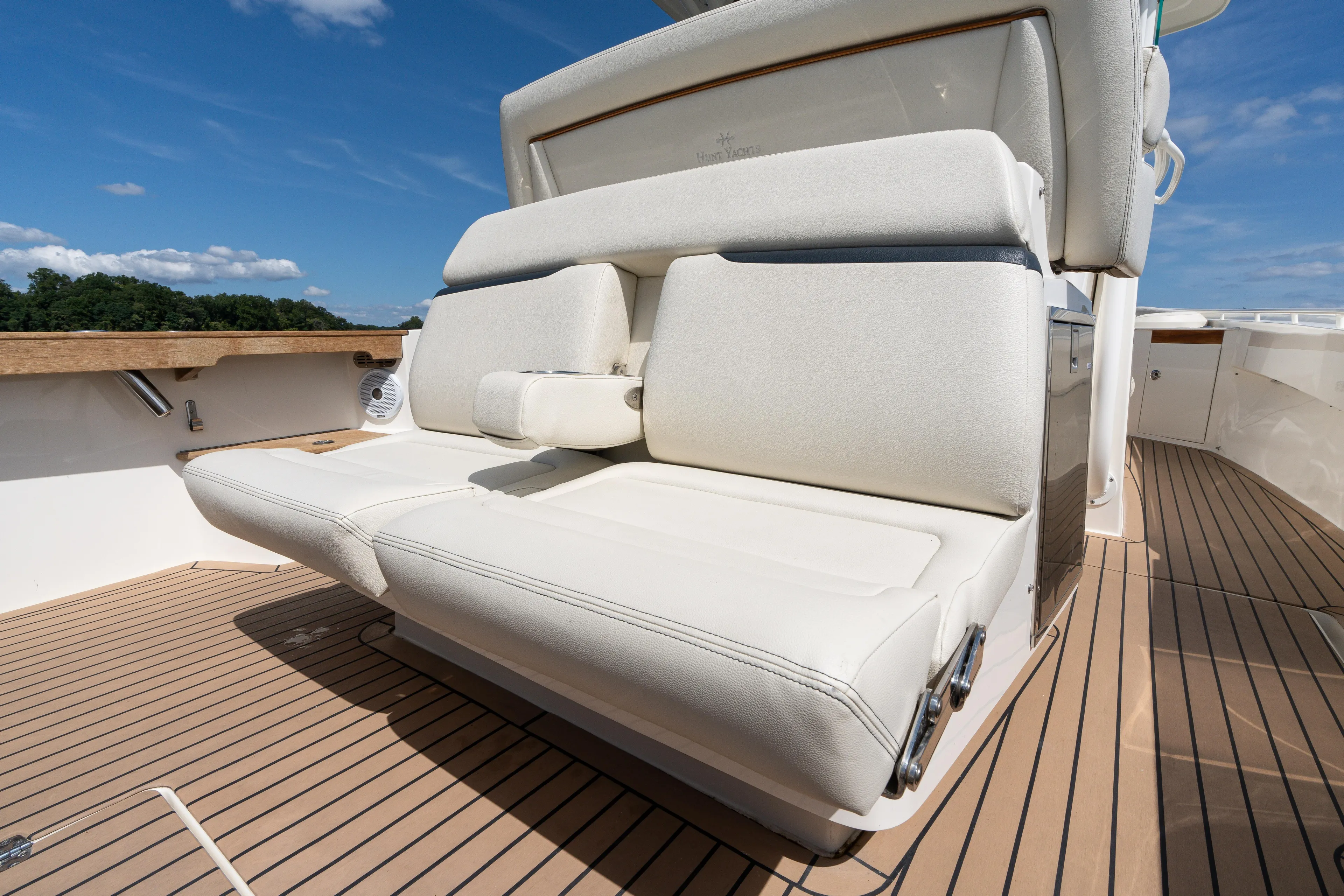 Hunt 32cc-035 Yacht Photos Pics 2019 Hunt Yachts 32CC boat with white seating and teak deck under blue sky.