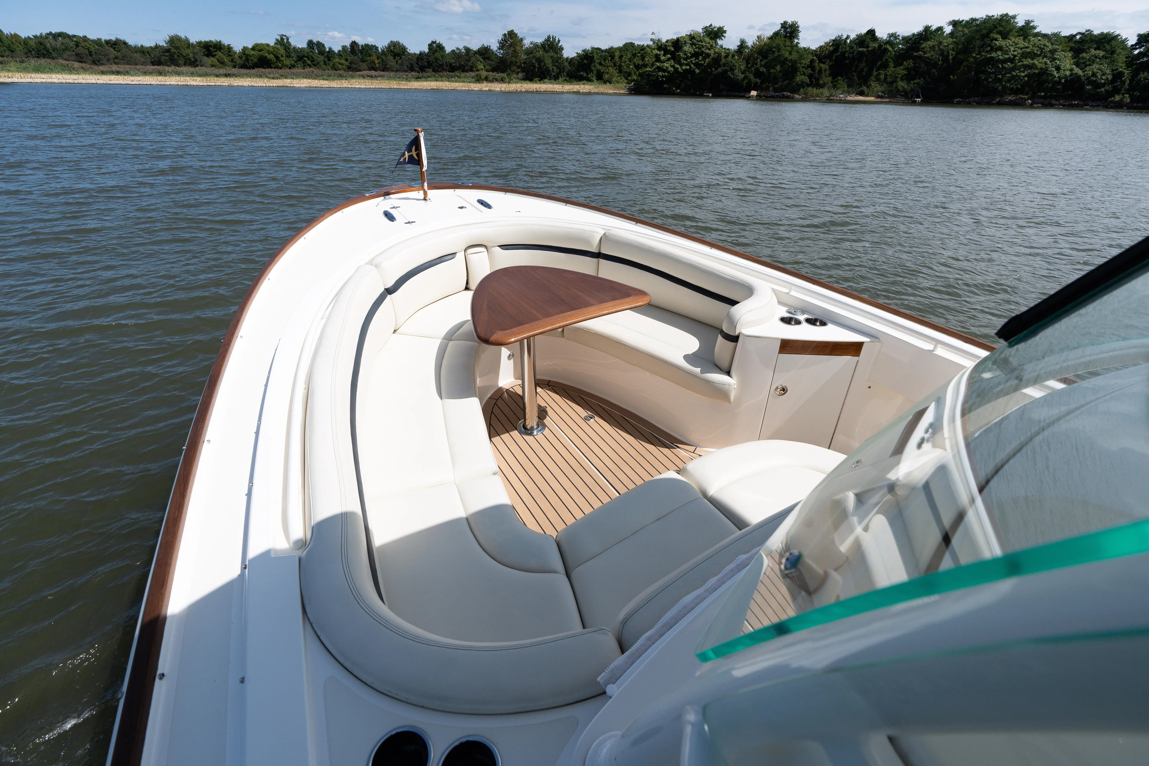 Hunt 32cc-035 Yacht Photos Pics 2019 Hunt Yachts 32CC boat with elegant seating and wooden table on calm water.