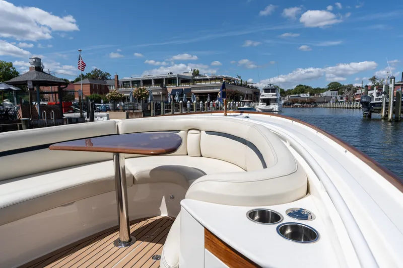 Hunt 32cc-035 Yacht Photos Pics 2019 Hunt Yachts 32CC with elegant seating and table, docked at a scenic marina.