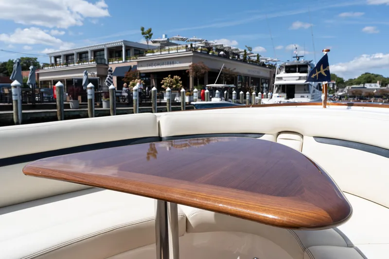 Hunt 32cc-035 Yacht Photos Pics 2019 Hunt Yachts 32CC with polished wooden table, docked near waterfront restaurant.