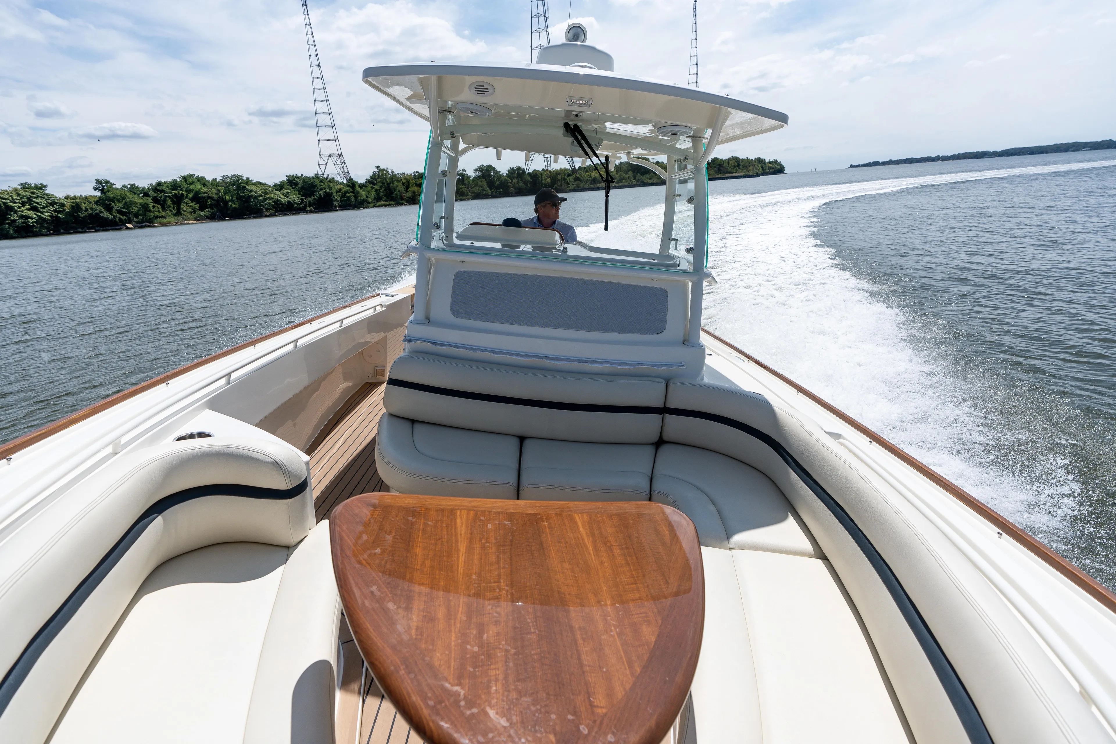 Hunt 32cc-035 Yacht Photos Pics 2019 Hunt Yachts 32CC cruising on a scenic waterway, featuring elegant seating and a wooden table.