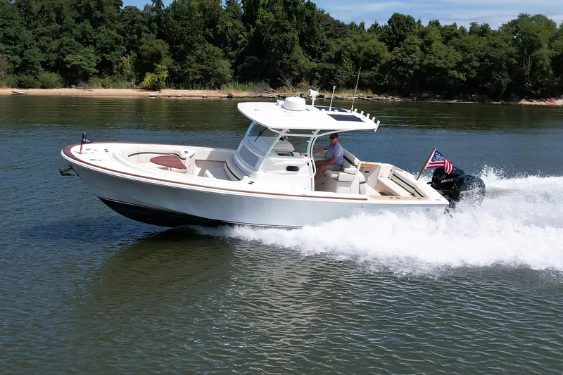 Hunt 32cc-035 Yacht Photos Pics 2019 Hunt Yachts 32CC cruising on a lake with lush green shoreline.