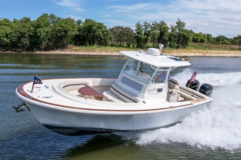 Hunt 32cc-035 Yacht Photos Pics 2019 Hunt Yachts 32CC cruising on a scenic waterway with lush greenery.