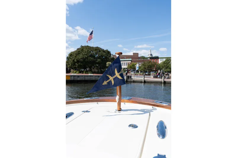 Hunt 32cc-035 Yacht Photos Pics 2019 Hunt Yachts 32CC boat with flag, docked near waterfront, American flag in background.