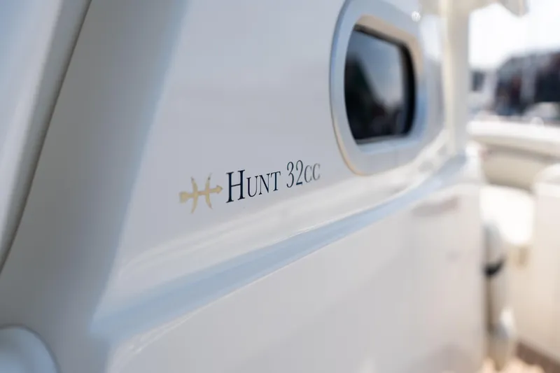 Hunt 32cc-035 Yacht Photos Pics 2019 Hunt Yachts 32CC boat exterior with logo and window detail.