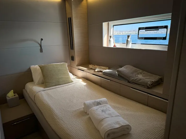 Esperance Yacht Photos Pics Luxurious cabin interior of 2024 Lagoon 55 yacht with cozy bedding and ocean view.