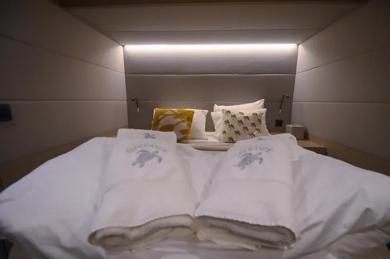 Esperance Yacht Photos Pics Luxurious bedroom interior of 2024 Lagoon 55 yacht with plush bedding and ambient lighting.