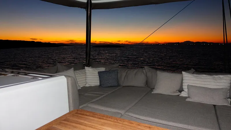 Esperance Yacht Photos Pics Luxurious Lagoon 55 yacht interior at sunset, 2024 model, with cozy seating and ocean view.