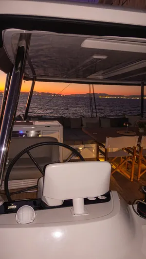 Esperance Yacht Photos Pics 2024 Lagoon 55 yacht interior at sunset, featuring helm and seating area.