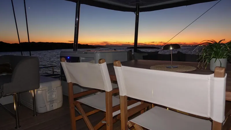 Esperance Yacht Photos Pics Sunset view from 2024 Lagoon 55 yacht's deck with chairs and table.