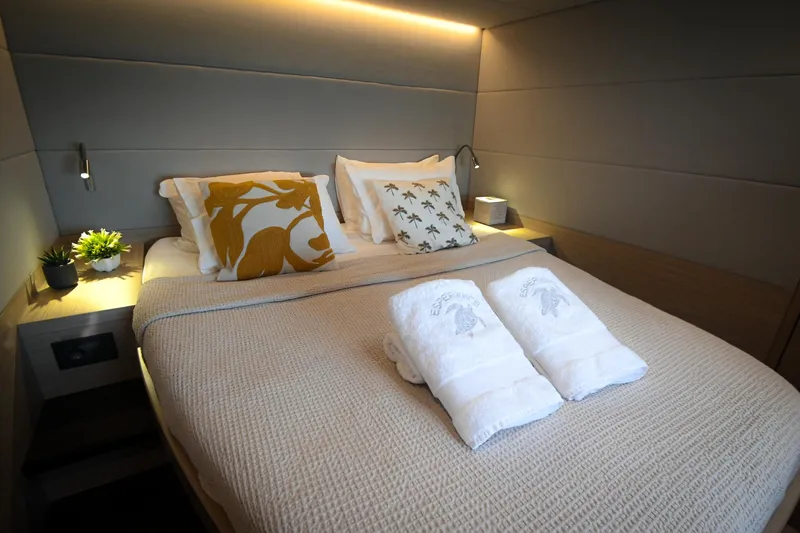 Esperance Yacht Photos Pics Luxurious bedroom interior of 2024 Lagoon 55 yacht with elegant bedding and ambient lighting.