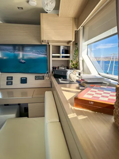 Esperance Yacht Photos Pics Luxurious interior of 2024 Lagoon 55 yacht with TV, chessboard, and ocean view.