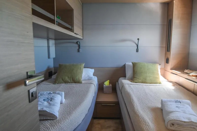 Esperance Yacht Photos Pics Luxurious twin cabin interior of 2024 Lagoon 55 yacht, featuring modern design and cozy bedding.