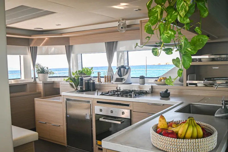 Esperance Yacht Photos Pics Modern kitchen interior of 2024 Lagoon 55 yacht with ocean view and fresh fruit basket.
