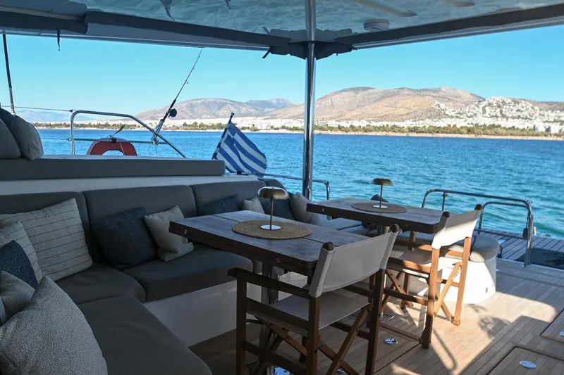 Esperance Yacht Photos Pics Luxurious 2024 Lagoon 55 yacht deck with seating, tables, and scenic ocean view.