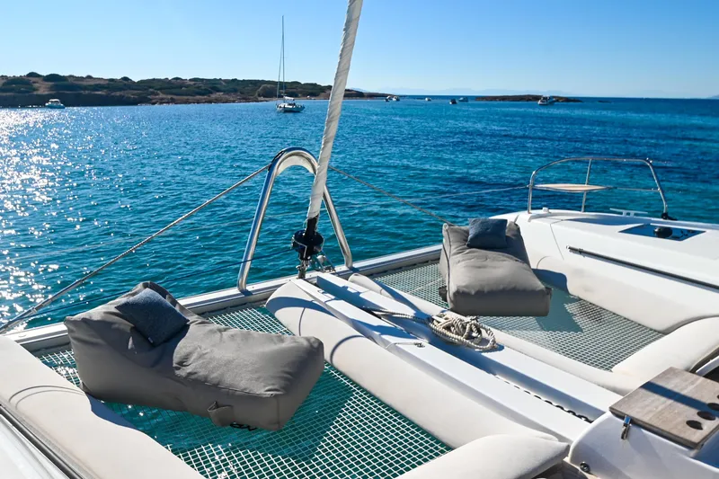 Esperance Yacht Photos Pics Luxurious Lagoon 55 catamaran deck with sun loungers, 2024 model, on serene blue waters.