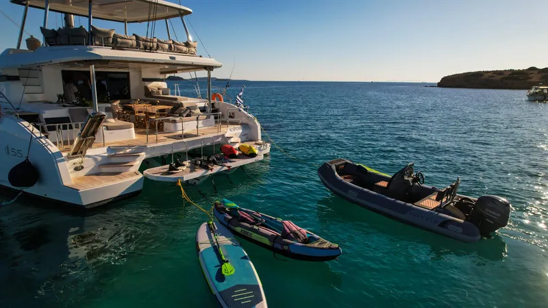 Esperance Yacht Photos Pics Luxurious 2024 Lagoon 55 yacht with paddleboards and dinghy in serene blue waters.