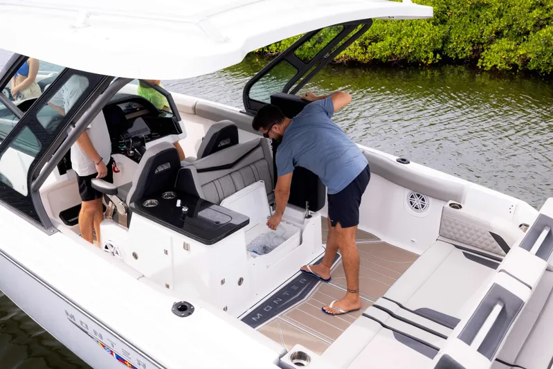  Yacht Photos Pics 2026 Monterey ELITE 30 boat interior with people, featuring seating and storage, on calm water.