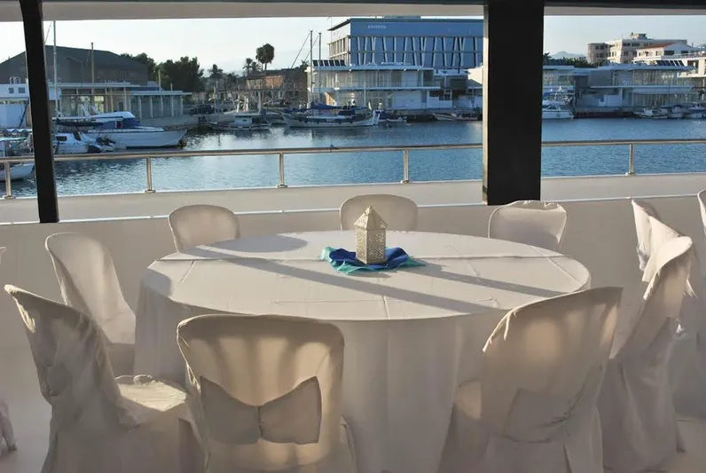 Salone Yacht Photos Pics Elegant dining setup on a 2015 Power Catamaran with marina view.