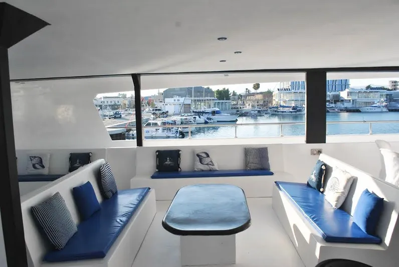 Salone Yacht Photos Pics Spacious 2015 Power Catamaran interior with blue seating and marina view.