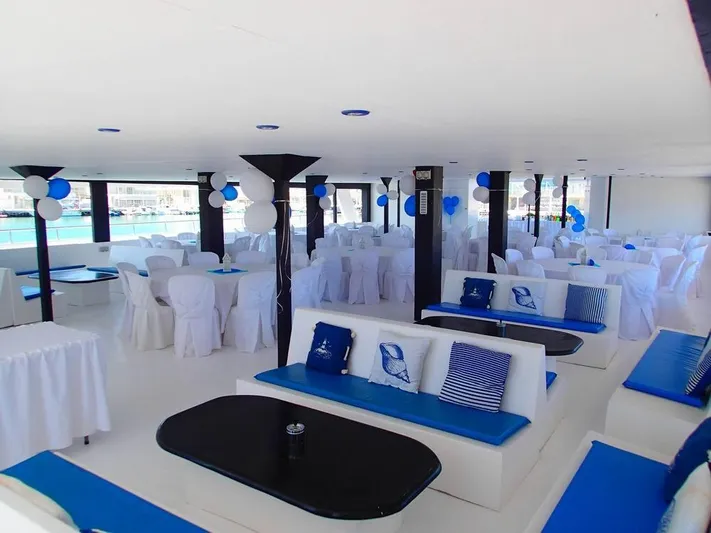 Salone Yacht Photos Pics Luxurious 2015 Power Catamaran interior with elegant white and blue seating, decorated for an event.