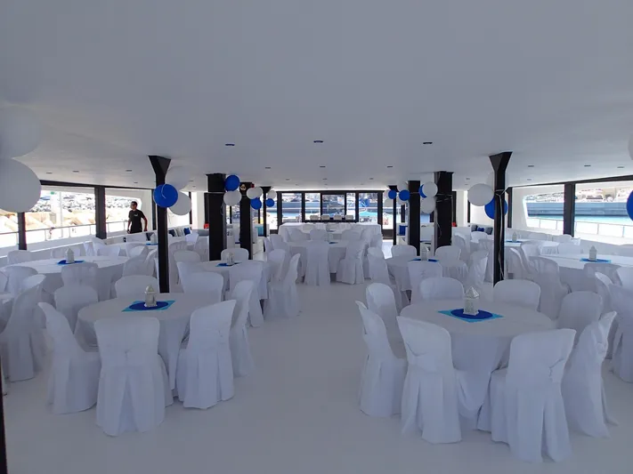 Salone Yacht Photos Pics 2015 Power Catamaran interior setup for event with white tablecloths and blue decorations.