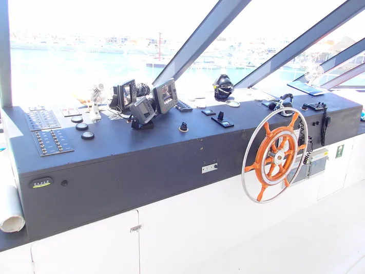 Salone Yacht Photos Pics 2015 Power Catamaran control panel with navigation equipment and steering wheel.