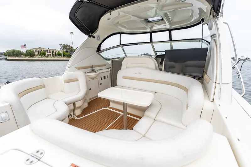  Yacht Photos Pics 2008 Sea Ray 38 Sundancer yacht interior with white seating and table, docked by waterfront.