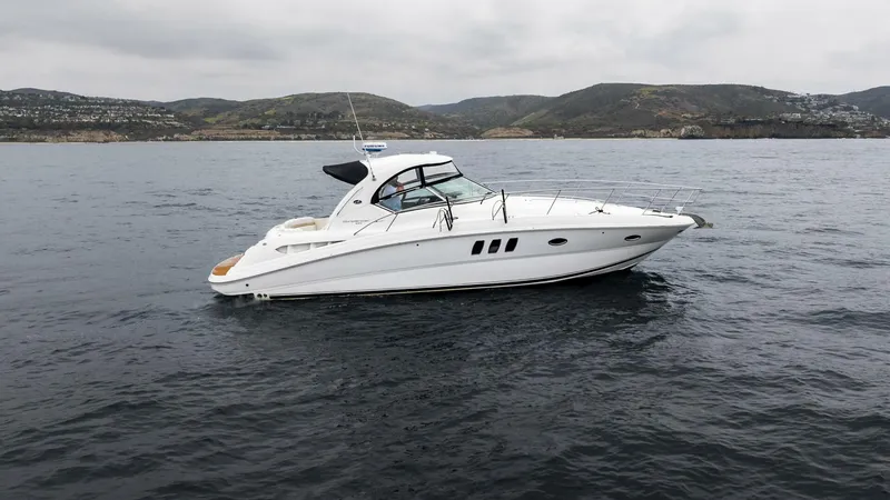  Yacht Photos Pics 2008 Sea Ray 38 Sundancer yacht on calm waters with scenic hills in the background.