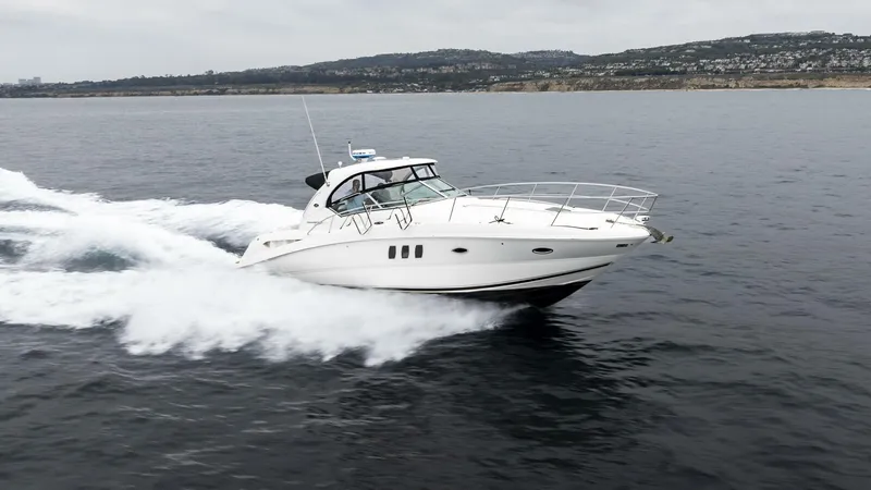  Yacht Photos Pics 2008 Sea Ray 38 Sundancer cruising on open water, with scenic coastline in the background.