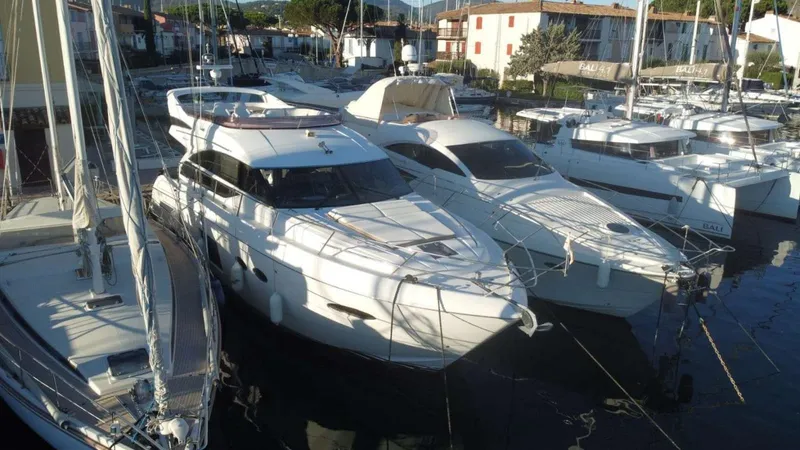  Yacht Photos Pics 2013 Princess Flybridge 52 Motor Yacht docked among other boats in a marina.