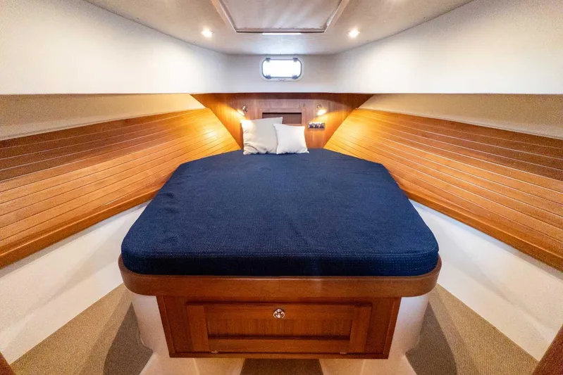  Yacht Photos Pics Cozy cabin interior of 2020 Targa 32 boat with wooden paneling and blue bedding.
