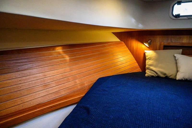 Yacht Photos Pics Cozy cabin interior of 2020 Targa 32 boat with wooden paneling and blue bedding.