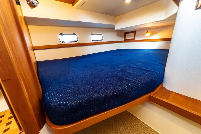  Yacht Photos Pics Cozy cabin interior of 2020 Targa 32 boat with blue bedding and wooden accents.