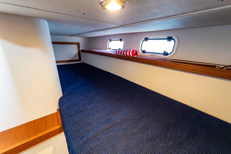  Yacht Photos Pics 2020 Targa 32 cabin interior with blue bedding and wooden accents.