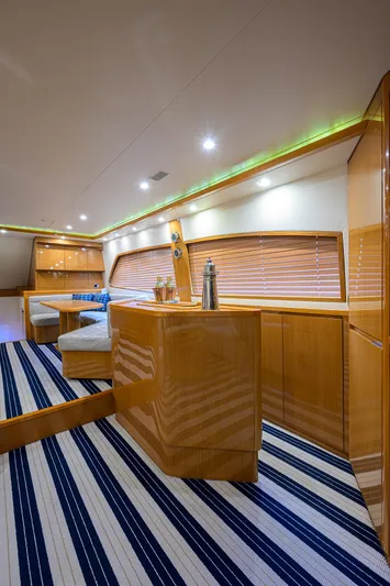 Goin Deep Yacht Photos Pics Luxurious interior of a 2014 Bertram 700 yacht with modern wood finishes and striped flooring.