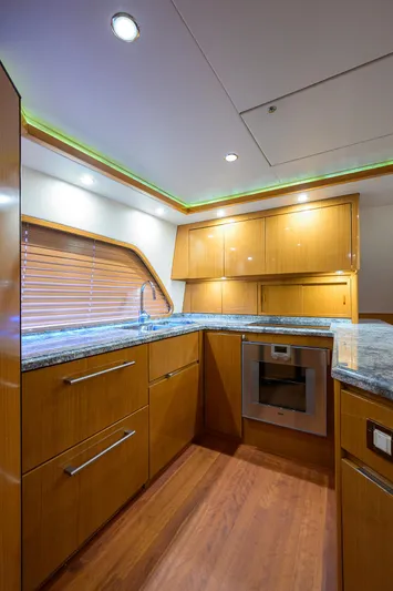 Goin Deep Yacht Photos Pics Luxurious kitchen interior of a 2014 Bertram 700 yacht with modern wood cabinetry.