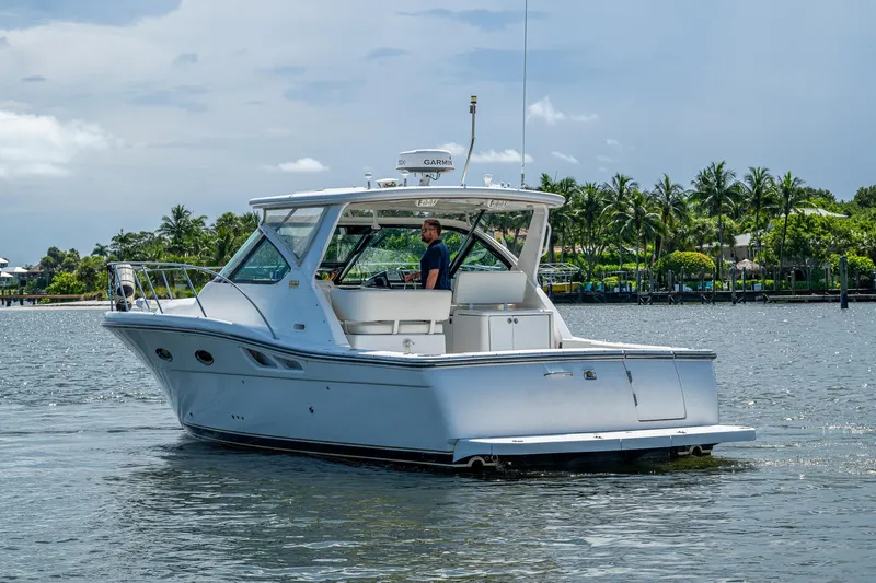  Yacht Photos Pics 2008 Tiara Yachts 3200 Open cruising on a sunny day near palm-lined shore.