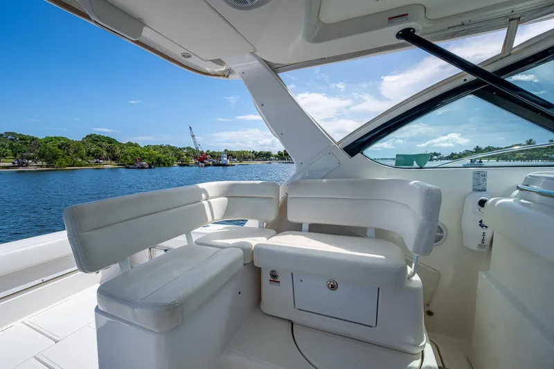  Yacht Photos Pics 2008 Tiara Yachts 3200 Open interior with white seating, overlooking serene water and lush greenery.