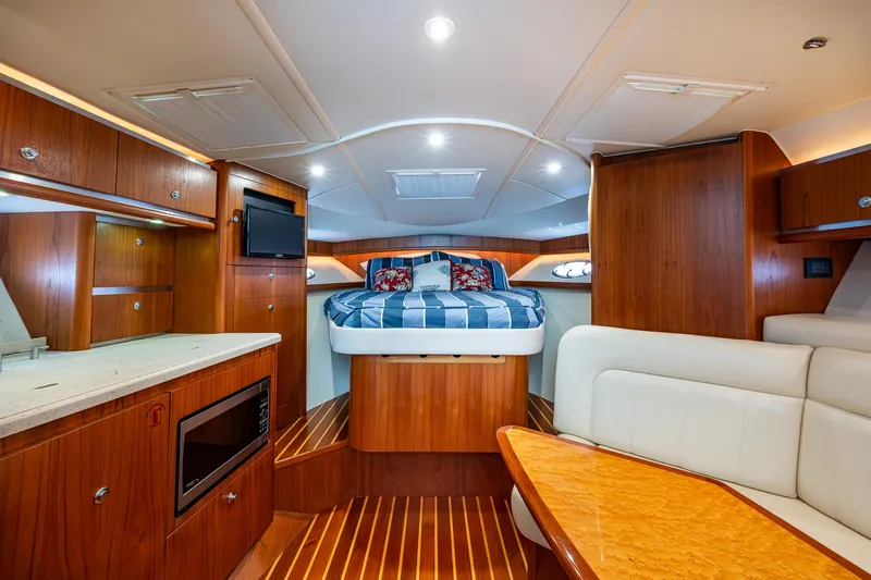  Yacht Photos Pics Luxurious interior of 2008 Tiara Yachts 3200 Open with wood finish and cozy bed.