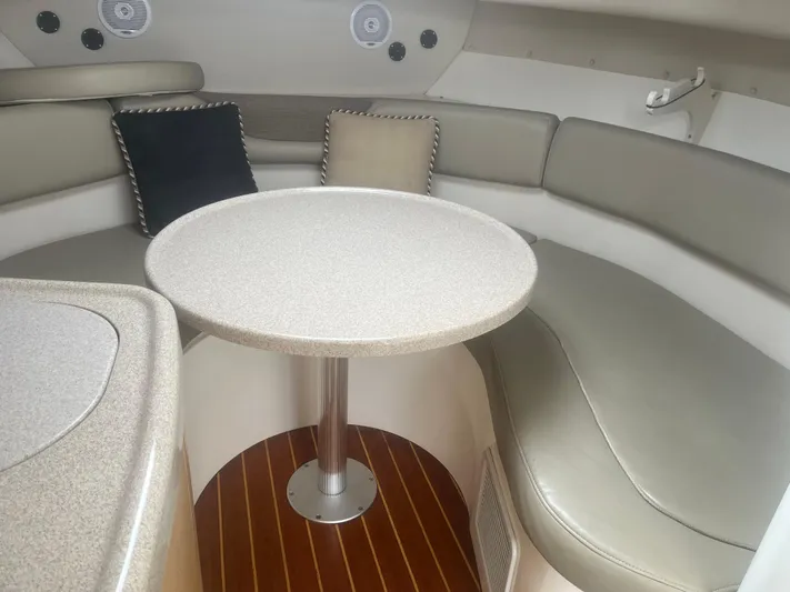  Yacht Photos Pics Interior of 2002 Boston Whaler 295 Conquest WA with cushioned seating and round table.