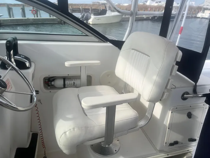  Yacht Photos Pics Boston Whaler 295 Conquest WA 2002 helm seat with steering wheel and fire extinguisher.
