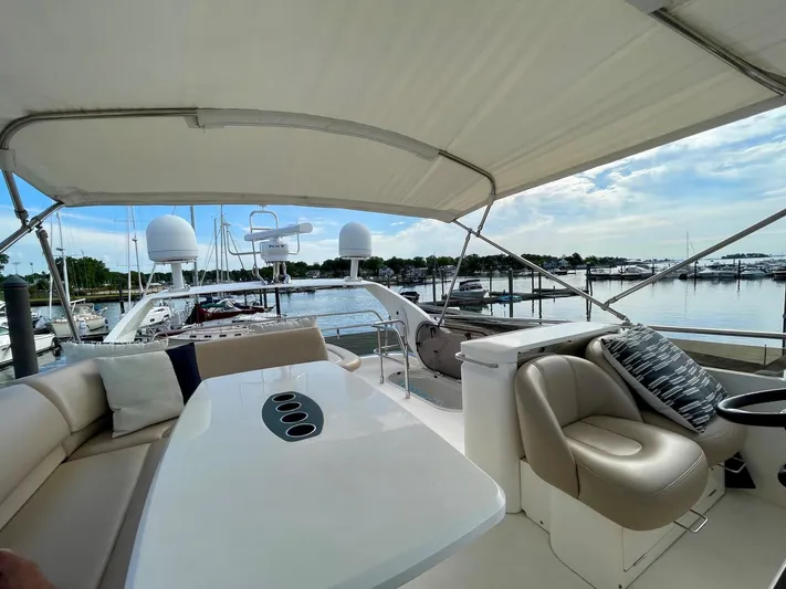 Ahdorned Yacht Photos Pics Luxurious 2009 Princess F54 yacht interior with seating and table, docked at marina.