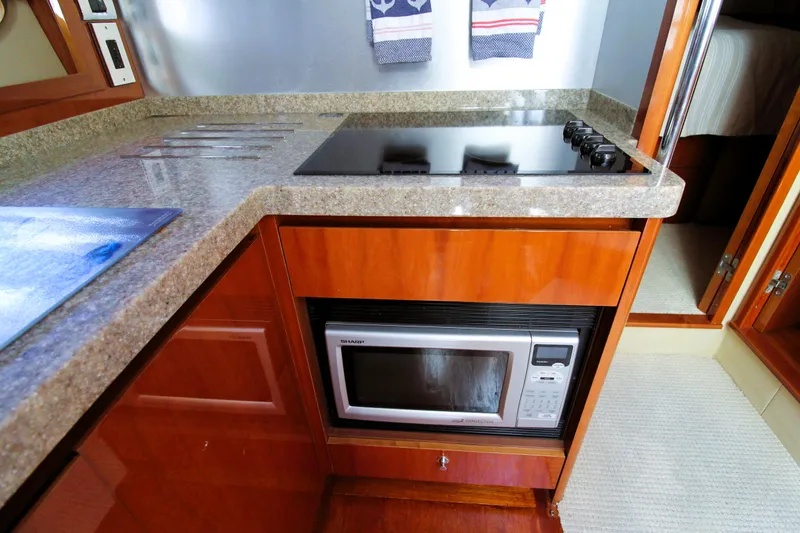 Ahdorned Yacht Photos Pics Modern yacht kitchen with stove, microwave, and wooden cabinetry in a 2009 Princess F54.