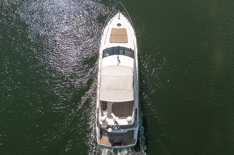 Ahdorned Yacht Photos Pics Aerial view of 2009 Princess F54 yacht cruising on calm water.