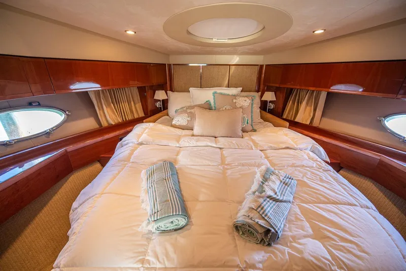 Ahdorned Yacht Photos Pics Luxurious cabin interior of 2009 Princess F54 yacht with plush bedding and elegant wood finishes.