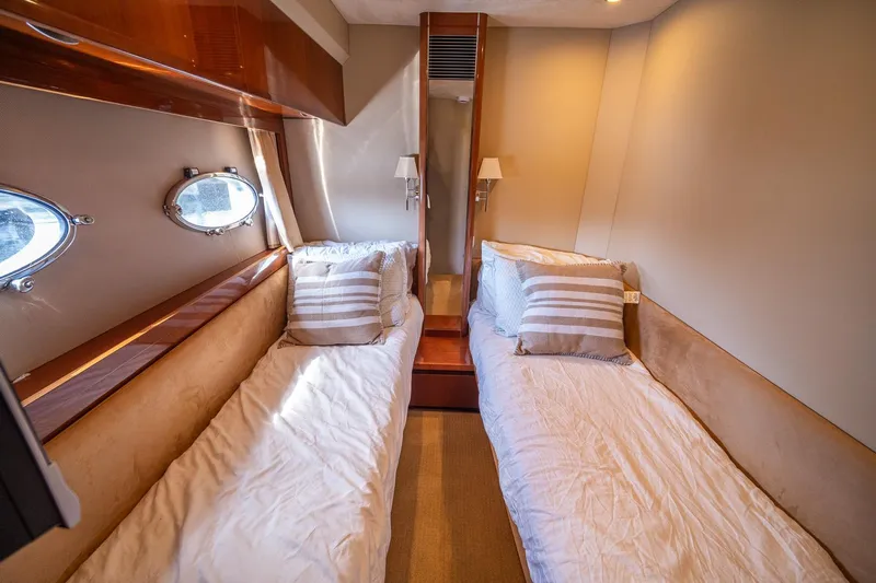 Ahdorned Yacht Photos Pics Luxurious twin cabin interior of 2009 Princess F54 yacht with elegant bedding and porthole windows.
